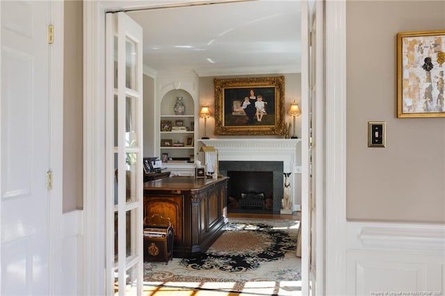 interior space featuring a fireplace, crown molding, and built in shelves
