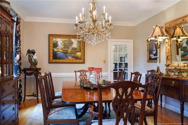 dining space featuring ornamental molding, wood finished floors, and a chandelier