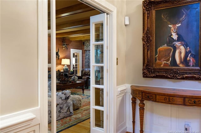 hallway featuring a wainscoted wall and wood finished floors