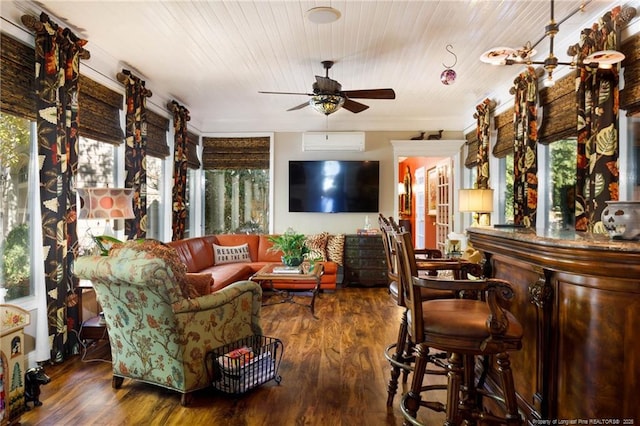 living room featuring wood finished floors, a wealth of natural light, a wall mounted AC, and ceiling fan