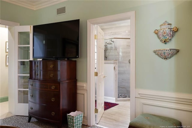 bedroom with ornamental molding, ensuite bath, and visible vents