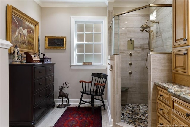 full bathroom featuring vanity, crown molding, baseboards, and a shower stall