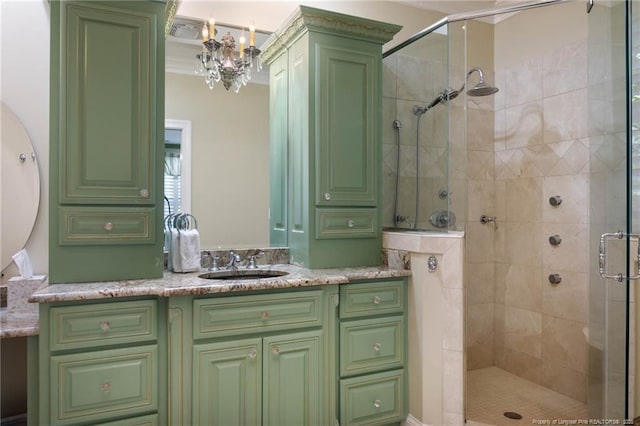 full bathroom with vanity, crown molding, an inviting chandelier, and a shower stall