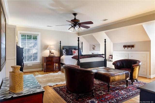 bedroom featuring baseboards, ornamental molding, visible vents, and light wood-style floors