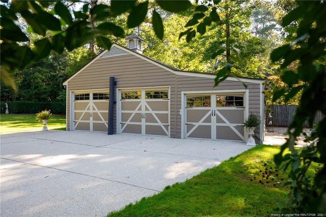 detached garage featuring fence