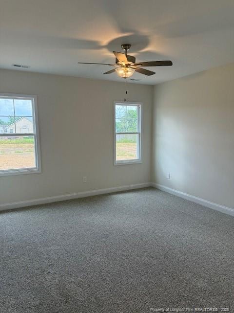 carpeted empty room featuring a wealth of natural light, baseboards, and a ceiling fan