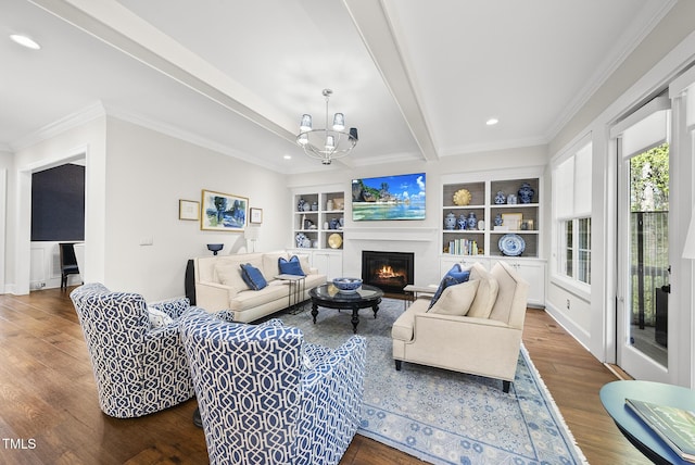 living area featuring dark wood-style floors, a warm lit fireplace, ornamental molding, beamed ceiling, and a chandelier