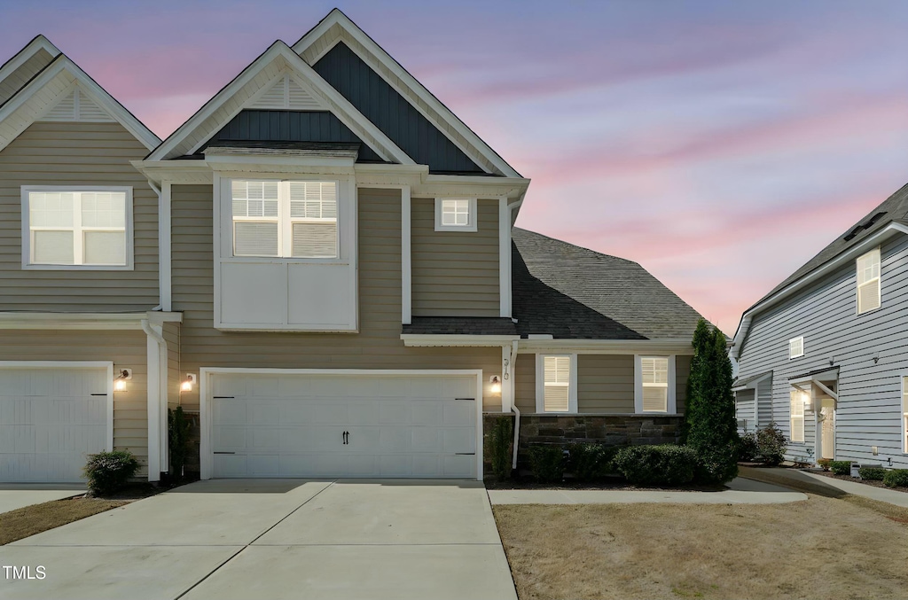 310 Shale Creek Dr, Durham, NC 27703 - view of front of house featuring driveway, stone siding, a garage, and board and batten siding