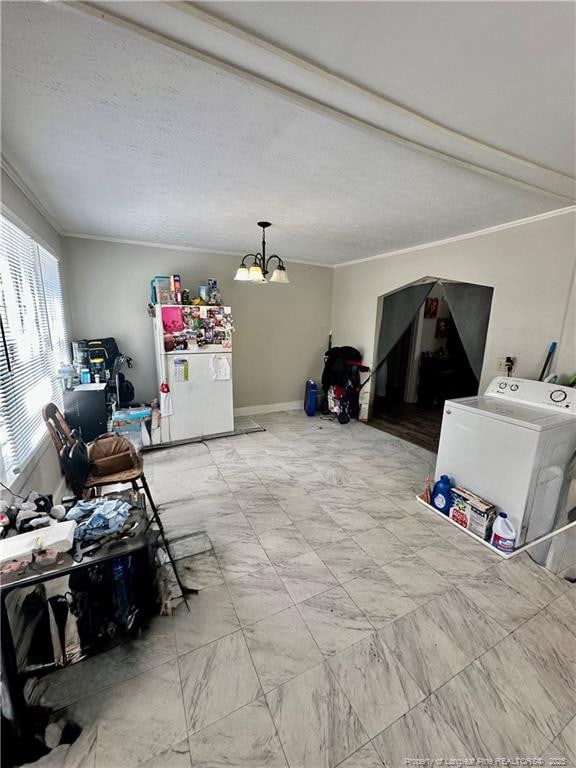 interior space with ornamental molding, an inviting chandelier, and washer / dryer