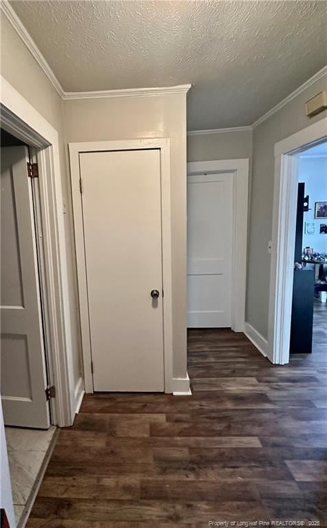 hallway featuring ornamental molding, a textured ceiling, and wood finished floors
