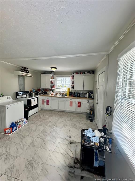 kitchen with washing machine and clothes dryer, a textured ceiling, marble finish floor, ornamental molding, and range with electric stovetop