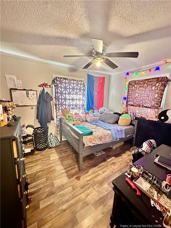 bedroom with wood finished floors, ceiling fan, and a textured ceiling
