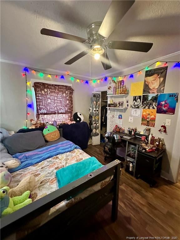 bedroom featuring ornamental molding, wood finished floors, and a ceiling fan