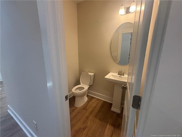 505 Chason Rd, Lumber Bridge, NC 28357 - bathroom with wood finished floors, toilet, baseboards, and a sink