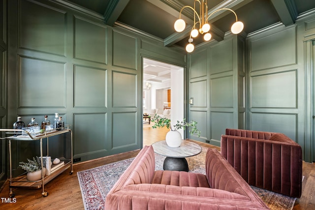 living area with coffered ceiling, ornamental molding, beamed ceiling, and a decorative wall