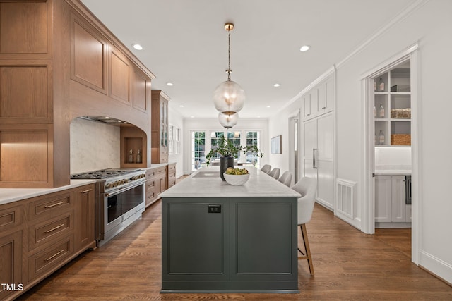 kitchen with a kitchen bar, double oven range, a center island, dark wood finished floors, and recessed lighting