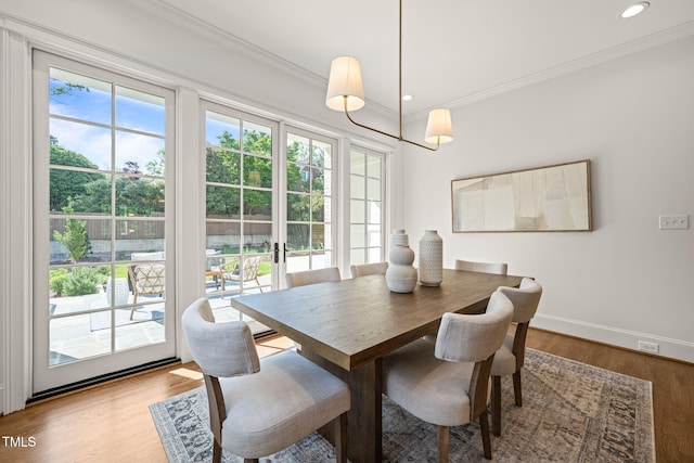 dining room with baseboards, ornamental molding, wood finished floors, and recessed lighting