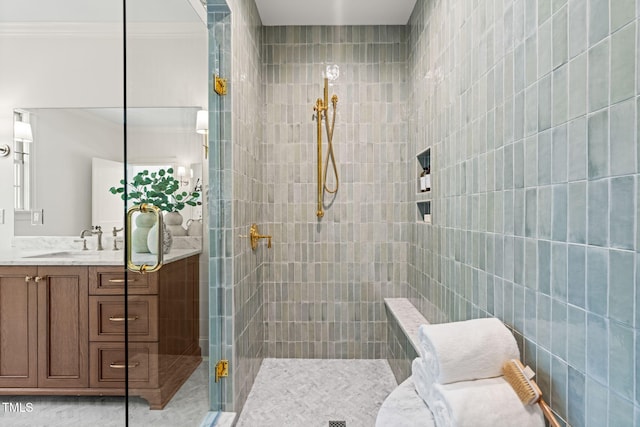 full bathroom featuring ornamental molding, tiled shower, and vanity