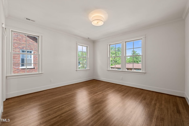 unfurnished room with baseboards, ornamental molding, and wood finished floors