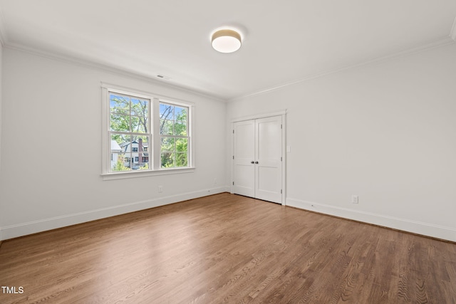 unfurnished room featuring baseboards, ornamental molding, and wood finished floors