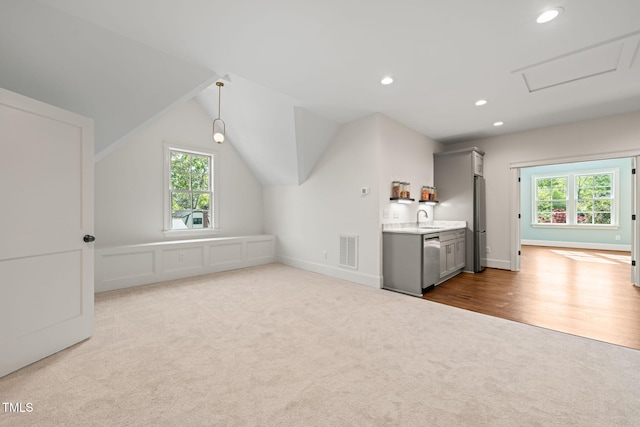 additional living space with a sink, carpet floors, attic access, recessed lighting, and visible vents