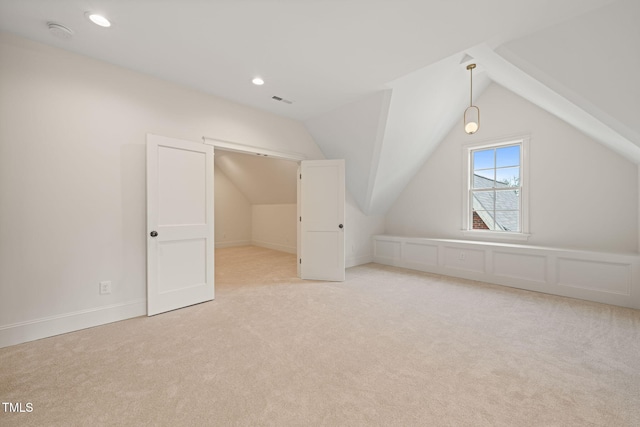 additional living space with recessed lighting, lofted ceiling, visible vents, and light carpet