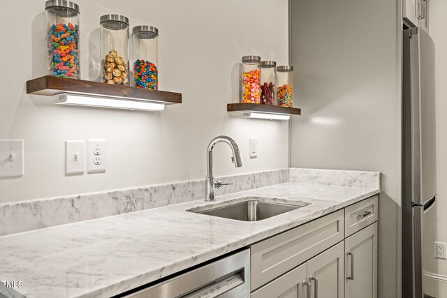 909 N Gregson St, Durham, NC 27701 - kitchen featuring open shelves, freestanding refrigerator, dishwashing machine, light stone counters, and a sink