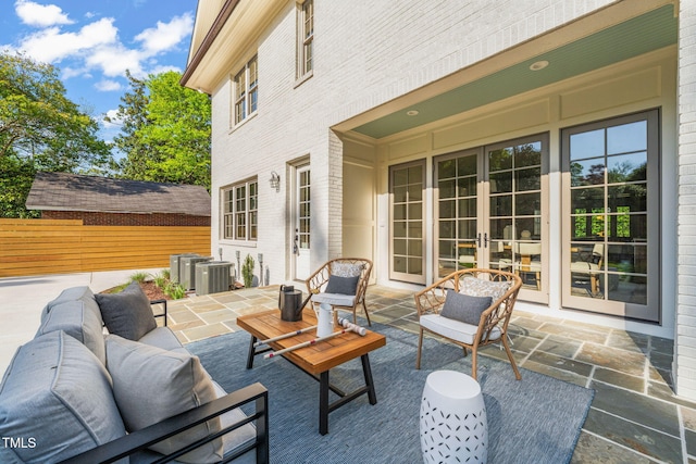 view of patio / terrace featuring an outdoor living space, central AC unit, fence, and french doors