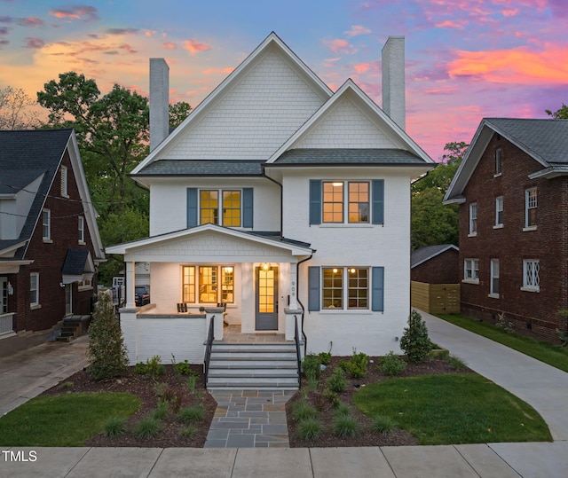 view of front of property featuring a chimney and a porch