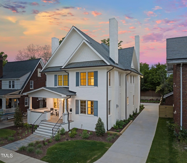 view of front facade featuring covered porch and a chimney