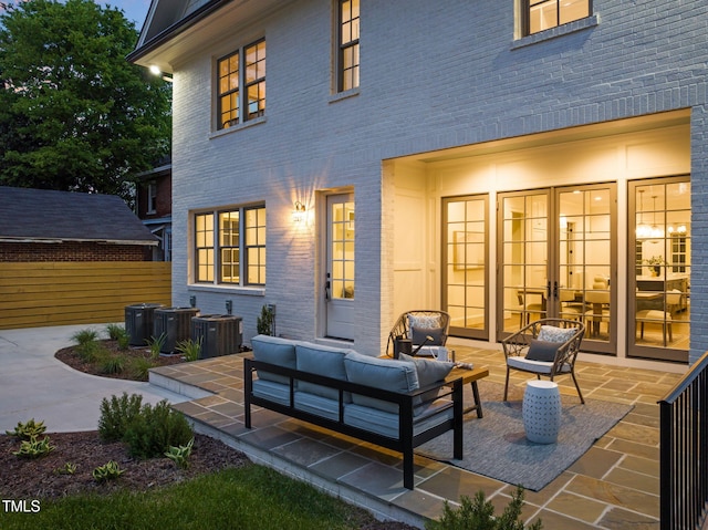 rear view of property featuring a patio, an outdoor hangout area, central air condition unit, and brick siding