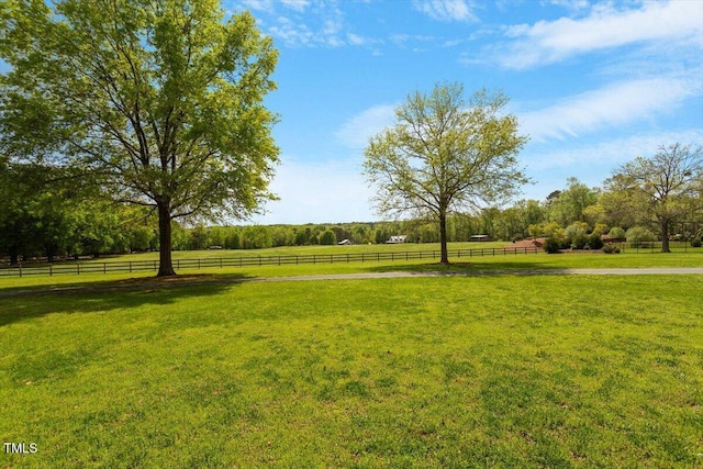 surrounding community featuring a rural view, a yard, and fence