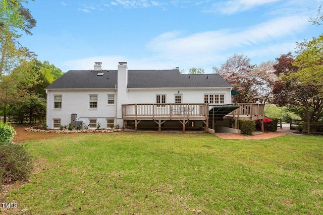 back of house with a wooden deck, a chimney, and a lawn