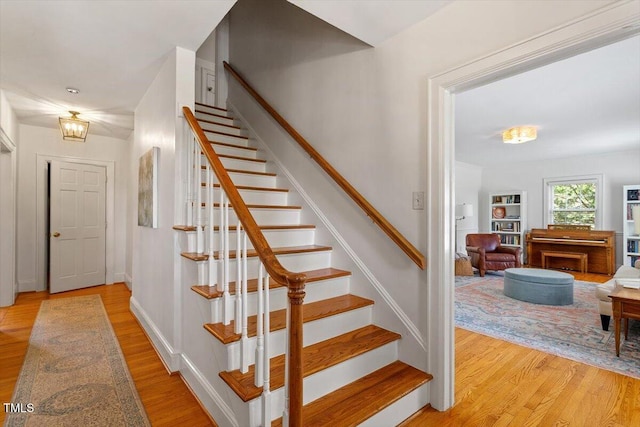 stairs featuring wood finished floors and baseboards