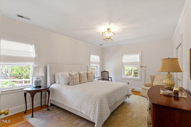 bedroom with visible vents, multiple windows, baseboards, and light wood-style flooring