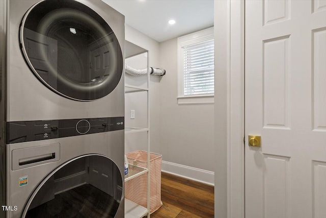 clothes washing area featuring baseboards, recessed lighting, stacked washer / drying machine, laundry area, and wood finished floors