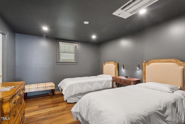 bedroom with recessed lighting and wood finished floors