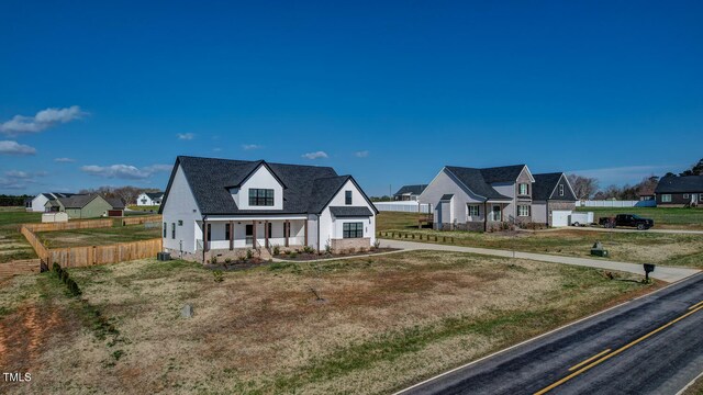 view of front of house with driveway, fence, a front lawn, a residential view, and a porch