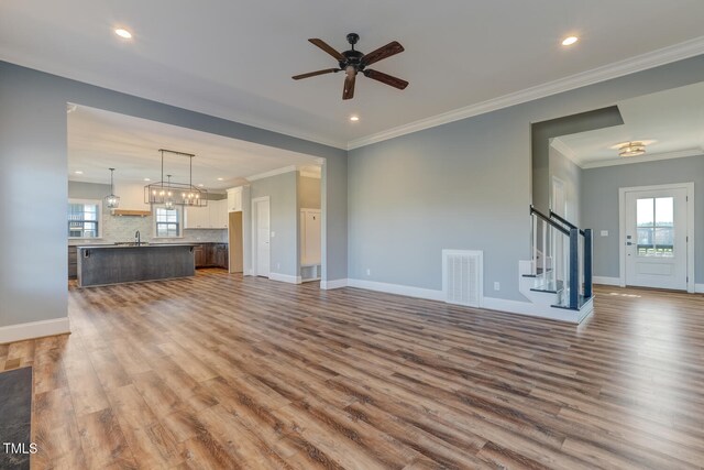 unfurnished living room featuring dark wood-type flooring, stairs, visible vents, and plenty of natural light
