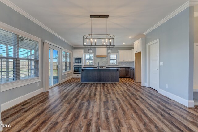 kitchen with built in microwave, ornamental molding, tasteful backsplash, and oven