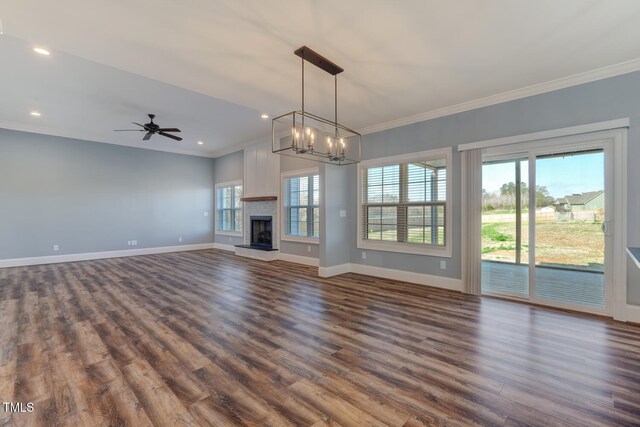unfurnished living room with baseboards, dark wood-style flooring, ornamental molding, and a healthy amount of sunlight