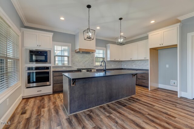 kitchen with dark wood finished floors, dark countertops, white cabinets, and a sink
