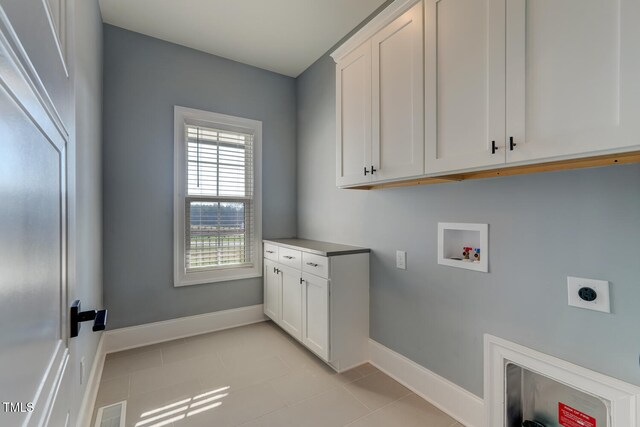 laundry area featuring hookup for a washing machine, baseboards, cabinet space, visible vents, and electric dryer hookup
