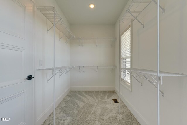 walk in closet with light carpet and visible vents