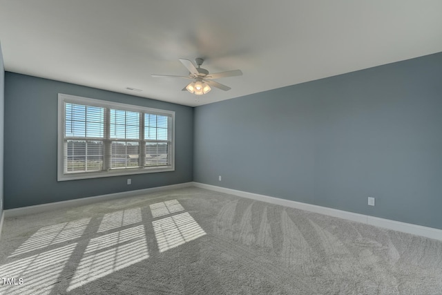 spare room with baseboards, ceiling fan, visible vents, and carpet