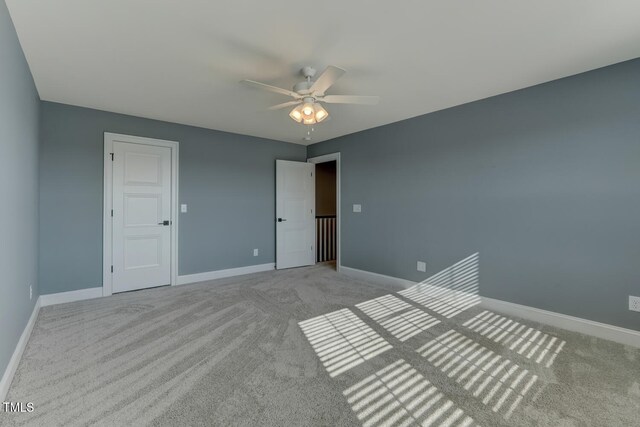 unfurnished bedroom featuring baseboards, a ceiling fan, and carpet