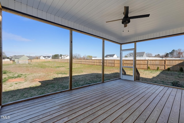 unfurnished sunroom with ceiling fan and a healthy amount of sunlight