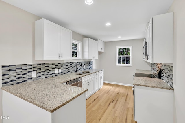 852 Fred Wilder Rd, Franklinton, NC 27525 - kitchen featuring a sink, backsplash, light stone counters, a peninsula, and recessed lighting