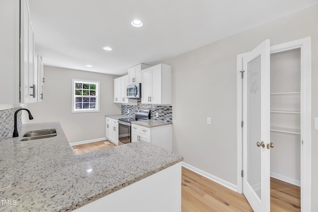 852 Fred Wilder Rd, Franklinton, NC 27525 - kitchen with stainless steel appliances, a sink, backsplash, light stone countertops, and recessed lighting