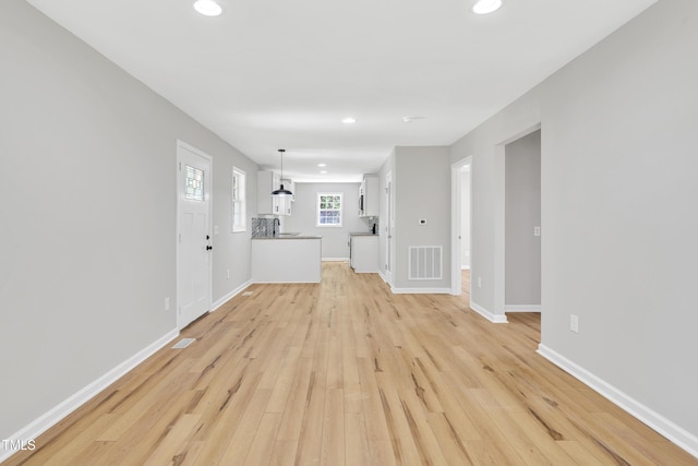 852 Fred Wilder Rd, Franklinton, NC 27525 - unfurnished living room featuring recessed lighting, light wood-style flooring, baseboards, and a sink